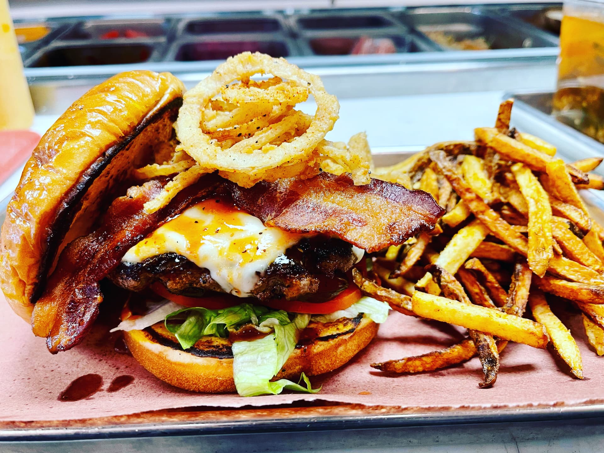 Bacon cheeseburger topped with crispy onion rings and served with fries