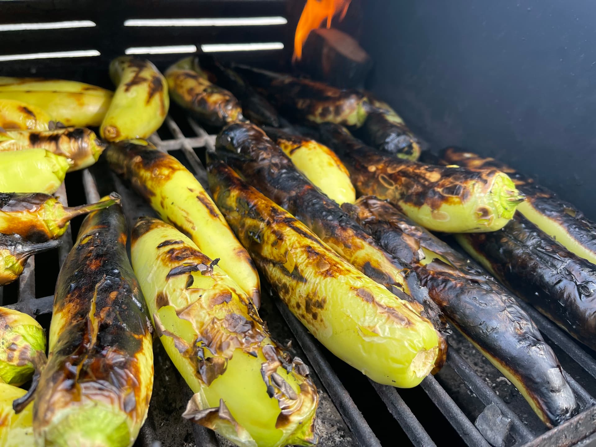 Fresh peppers blistering over the smoker flame