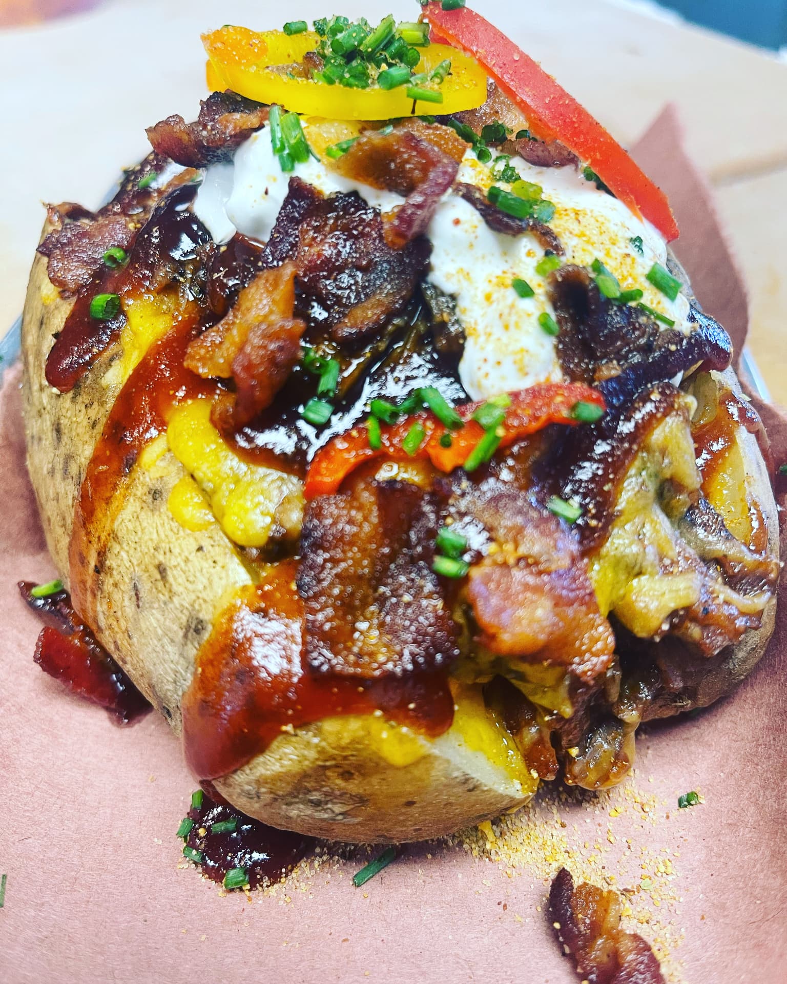 Loaded baked potato with barbecue, bacon and peppers