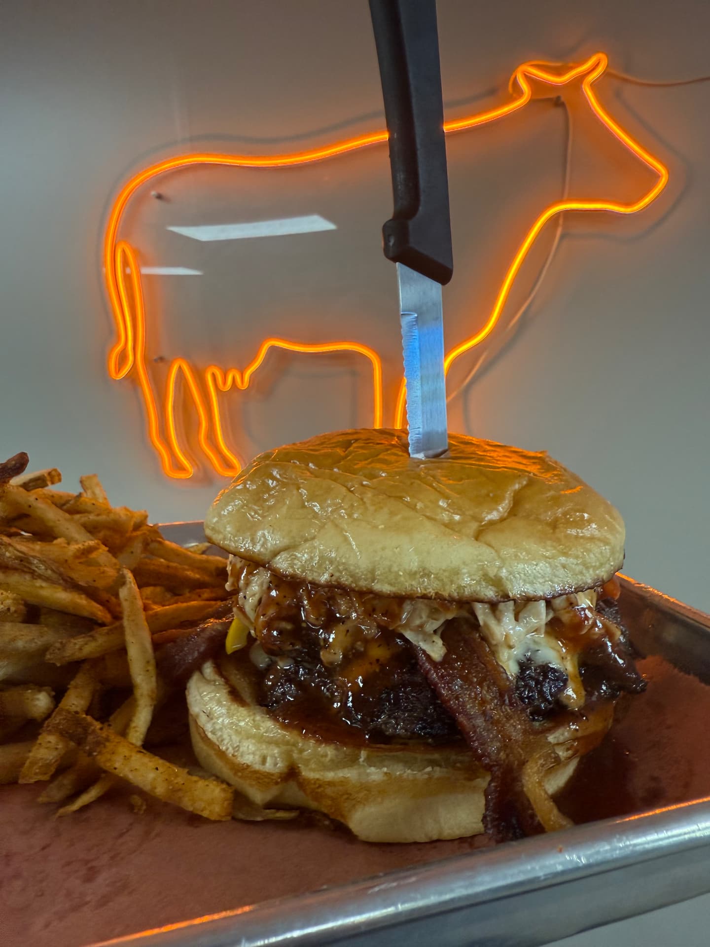 Barbecue bacon burger served beneath the orange cow sign