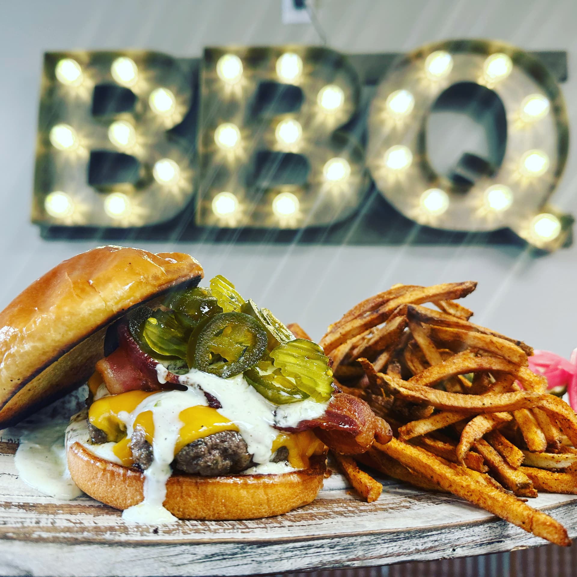 Bacon cheeseburger with jalapeños and seasoned fries