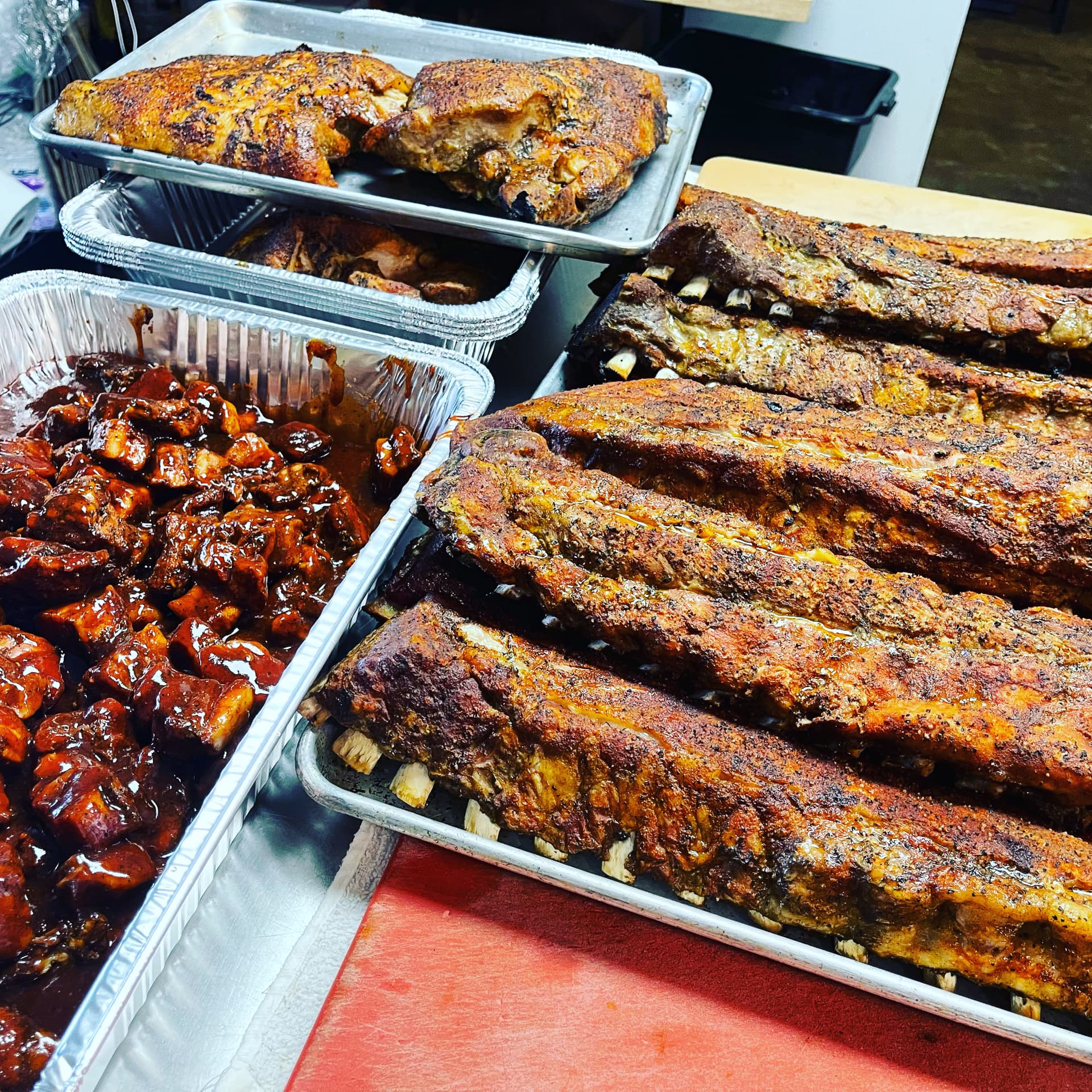Catering trays filled with smoked ribs, turkey and burnt ends