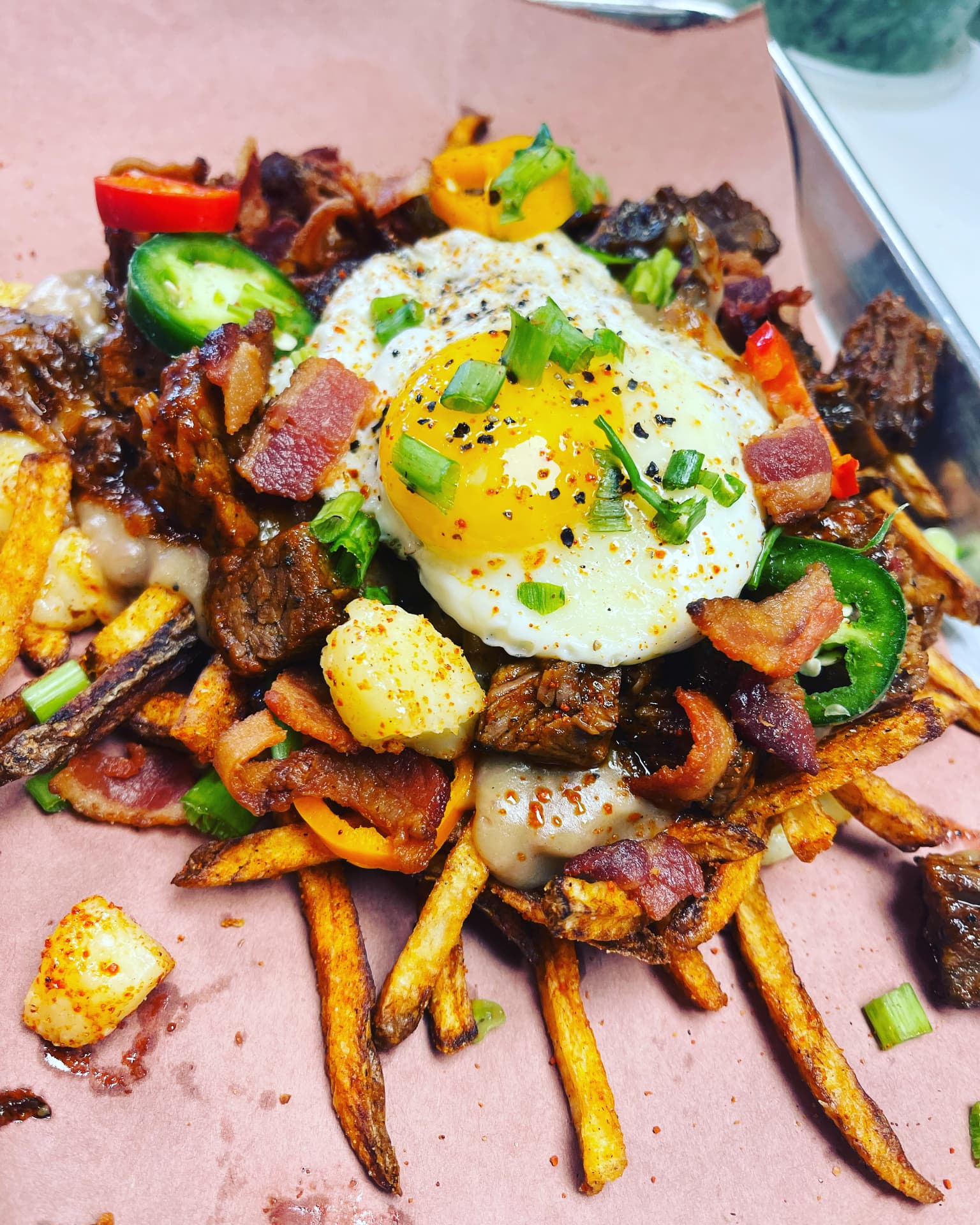 Loaded fries with brisket, bacon, peppers and a fried egg