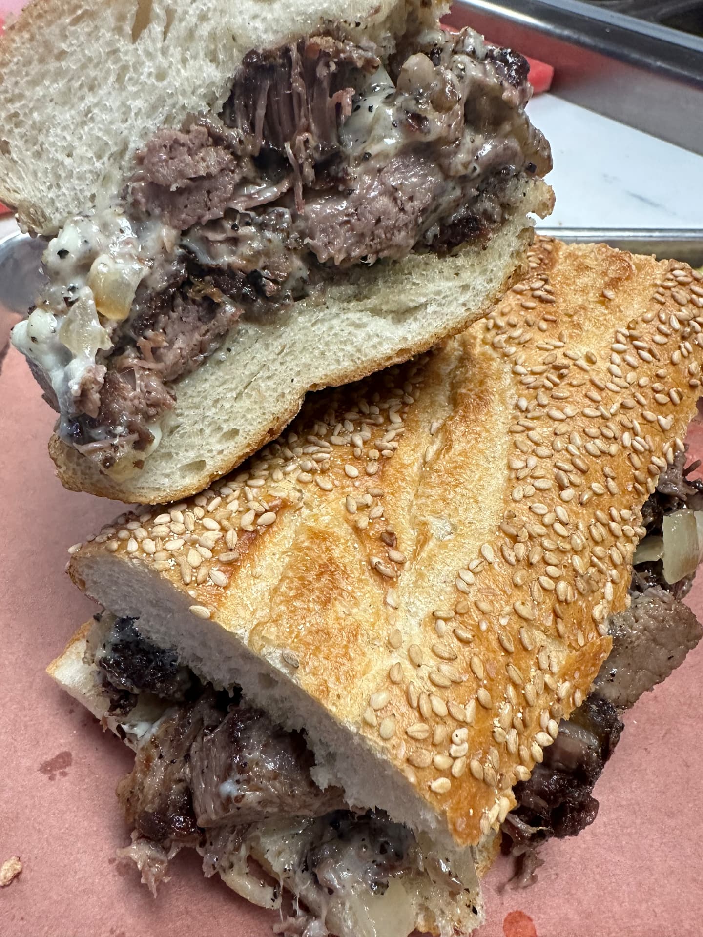 Smoked beef sandwich with melted cheese on a seeded roll